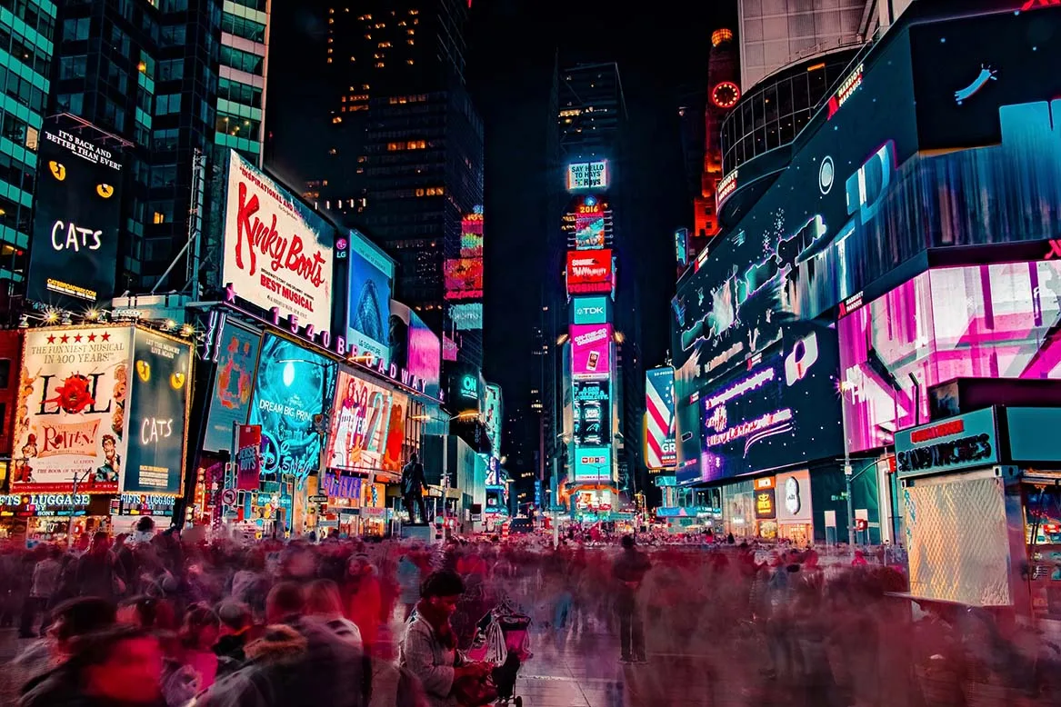 People walk quickly around the Theater District of Times Square